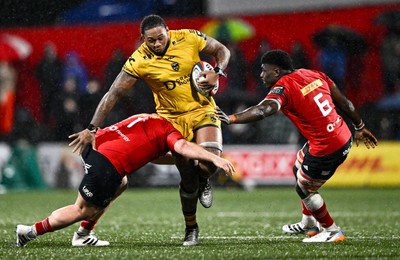 230126 - Munster v Dragons RFC - United Rugby Championship - Levi Douglas of Dragons is tackled by Jeremy Loughman, left, and Sean Edogdo of Munster
