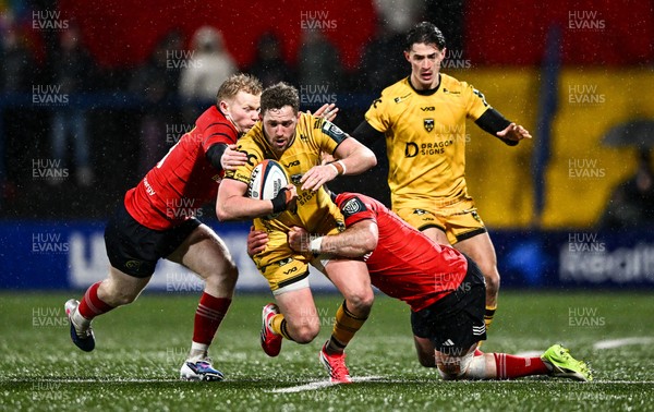 230126 - Munster v Dragons RFC - United Rugby Championship - Angus O'Brien of Dragons is tackled by Ethan Coughlan, left, and Diarmuid Barron of Munster
