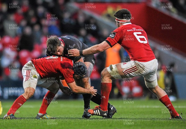 140216 - Munster v Ospreys - Guinness PRO12 - Sam Parry of Ospreys is tackled by Duncan Williams (left) and Billy Holland (right) of Munster