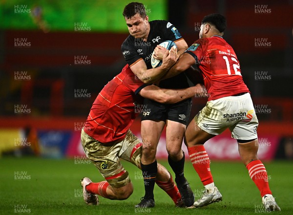170223 - Munster v Ospreys - United Rugby Championship - Michael Collins of Ospreys is tackled by Gavin Coombes, left, and Malakai Fekitoa of Munster