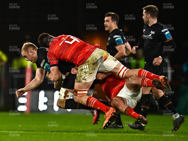 170223 - Munster v Ospreys - United Rugby Championship - Huw Sutton of Ospreys is tackled by Jean Kleyn and Niall Scannell of Munster
