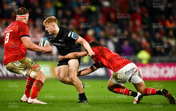 170223 - Munster v Ospreys - United Rugby Championship - Iestyn Hopkins of Ospreys is tackled by Antoine Frisch, right, and Gavin Coombes of Munster