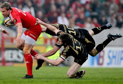 24.04.10  Munster v Ospreys... Munster Jean De Villiers tackled by Dan Biggar and Andrew Bishop of the Ospreys. 