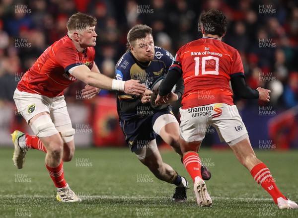 030323 - Munster v Scarlets - United Rugby Championship - Steff Evans of Scarlets in action against Munster players, from left, Jack O'Donoghue, and Joey Carbery