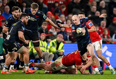 150225 - Munster v Scarlets - United Rugby Championship - Ioan Nicholas of Scarlets is tackled by Oli Jager of Munster