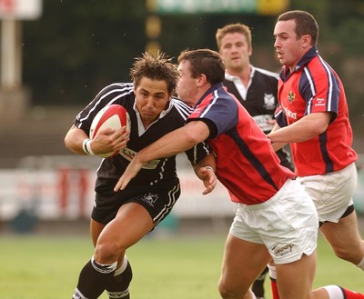 270903 - Neath-Swansea Ospreys v Munster - Celtic League - Ospreys' Gavin Henson is tackled by David Wallace