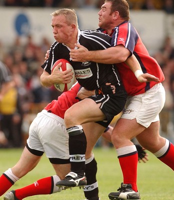 270903 - Neath-Swansea Ospreys v Munster - Celtic League - Ospreys' Barry Williams is tackled by Conrad O'Sullivan and Martin Cahill