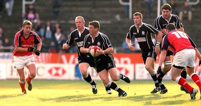 270903 - Neath-Swansea Ospreys v Munster - Celtic League - Ospreys' Scott Gibbs finds a gap between Mossie Lawlor (lt) and Conrad O'Sullivan (rt)