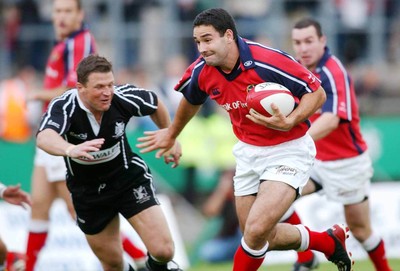 270903 - Neath-Swansea Ospreys v Munster - Celtic League - Munster's Jeremy Staunton slips past Scott Gibbs to score try