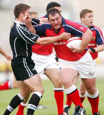 270903 - Neath-Swansea Ospreys v Munster - Celtic League - Munster's Simon Kerr holds off Andy Williams