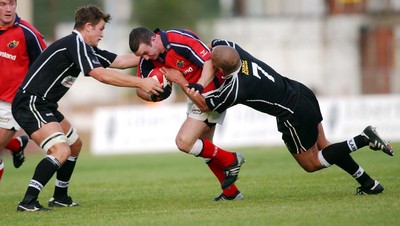 270903 - Neath-Swansea Ospreys v Munster - Celtic League - Ospreys' James Bater (left) and Gavin Thomas get hold of Munster's Conrad O'Sullivan