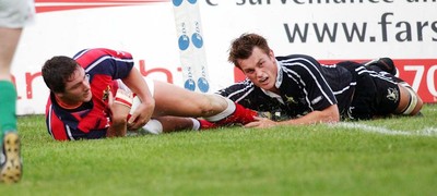 270903 - Neath-Swansea Ospreys v Munster - Celtic League - Munster's David Wallace dives over to score despite tackle from James Bater