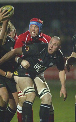 140203 - Neath v Llanelli - Welsh Premiership - Neath's Lyndon Bateman feeds the ball out as Dave Hodges tackles