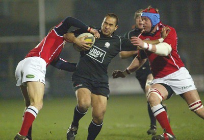 140203 - Neath v Llanelli - Welsh Premiership - Neath's Dave Tiueti is tackled by Dave Hodges (rt) and Garan Evans