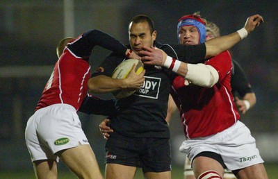 140203 - Neath v Llanelli - Welsh Premiership - Neath's Dave Tiueti is tackled by Dave Hodges (rt) and Garan Evans