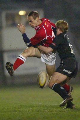 140203 - Neath v Llanelli - Welsh Premiership - Llanelli's Wayne Proctor is tackled by Shane Williams as he kicks ahead