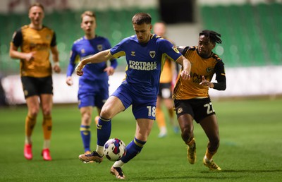 140323 - Newport County v AFC Wimbledon, EFL Sky Bet League 2 - Armani Little of AFC Wimbledon and Nathan Moriah-Welsh of Newport County compete for the ball