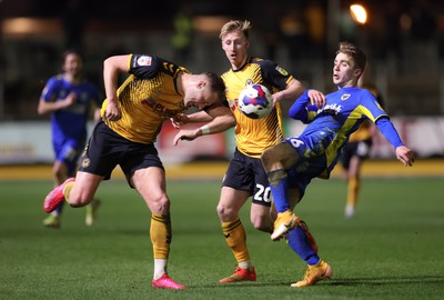 140323 - Newport County v AFC Wimbledon, EFL Sky Bet League 2 - Cameron Norman of Newport County takes a kick to the chest from Jack Currie of AFC Wimbledon as he looks to win the ball