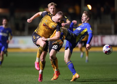 140323 - Newport County v AFC Wimbledon, EFL Sky Bet League 2 - Cameron Norman of Newport County takes a kick to the chest from Jack Currie of AFC Wimbledon as he looks to win the ball