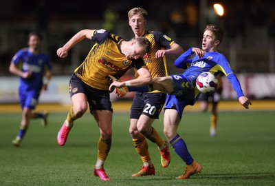 140323 - Newport County v AFC Wimbledon, EFL Sky Bet League 2 - Cameron Norman of Newport County takes a kick to the chest from Jack Currie of AFC Wimbledon as he looks to win the ball