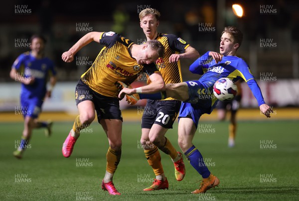 140323 - Newport County v AFC Wimbledon, EFL Sky Bet League 2 - Cameron Norman of Newport County takes a kick to the chest from Jack Currie of AFC Wimbledon as he looks to win the ball