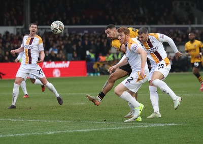 150225  Newport County v Bradford City, EFL Sky Bet League 2 -  Courtney Baker-Richardson of Newport County beats Brad Halliday of Bradford City and Aden Baldwin of Bradford City as he heads at goal