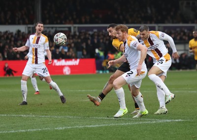 150225  Newport County v Bradford City, EFL Sky Bet League 2 -  Courtney Baker-Richardson of Newport County beats Brad Halliday of Bradford City and Aden Baldwin of Bradford City as he heads at goal