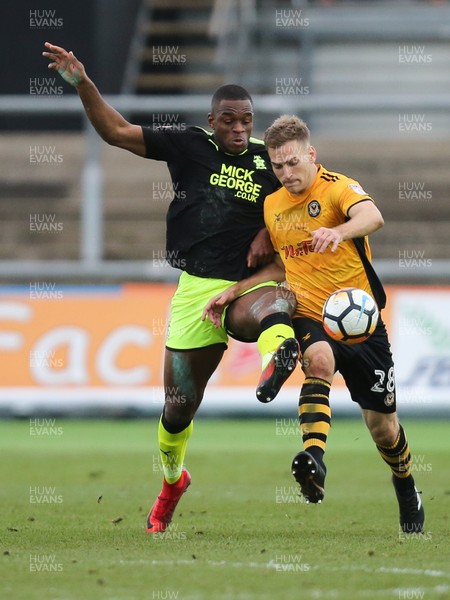 031217 - Newport County v Cambridge United, FA Cup Second Round - Mickey Demetriou of Newport County is challenged by Uche Ikpeazu of Cambridge United
