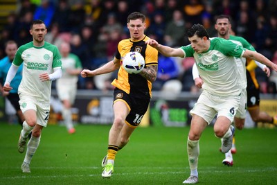 210226 - Newport County v Cambridge United - Sky Bet League 2 - Shane McLoughlin of Cambridge United, James Crole of Newport County and Kelland Watts of Cambridge United 