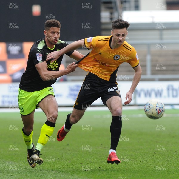 280418 - Newport County v Cambridge United - Sky Bet League 2 - Aaron Collins of Newport County holds off the challenge of Jake Carroll of Cambridge United