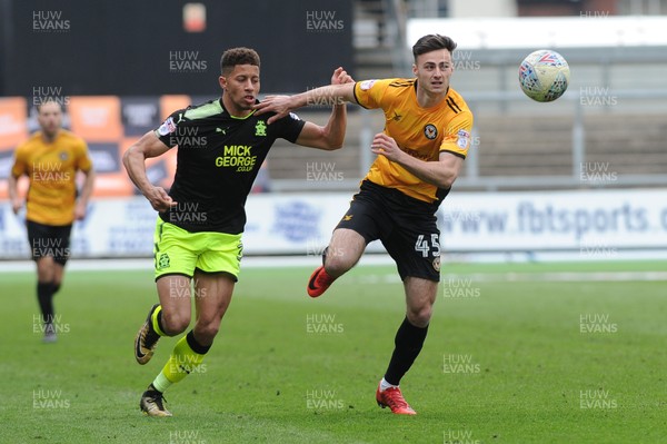 280418 - Newport County v Cambridge United - Sky Bet League 2 - Aaron Collins of Newport County holds off the challenge of Jake Carroll of Cambridge United
