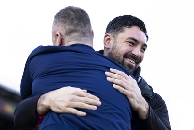 220225 - Newport County v Cheltenham Town - Sky Bet League 2 - Newport County goalkeeper Nick Townsend hugs Cheltenham Town manager Michael Flynn ahead of the match