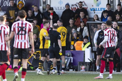 220225 - Newport County v Cheltenham Town - Sky Bet League 2 - Courtney Baker-Richardson of Newport County is shown a red card by Referee Jeremy Simpson