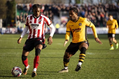 220225 - Newport County v Cheltenham Town - Sky Bet League 2 - Geoffroy Bony of Newport County in action against Ethon Archer of Cheltenham Town