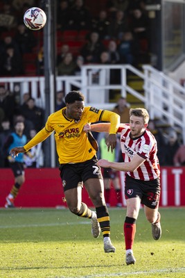 220225 - Newport County v Cheltenham Town - Sky Bet League 2 - Bobby Kamwa of Newport County in action against Darragh Power of Cheltenham Town