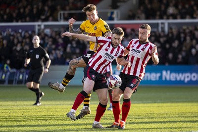 220225 - Newport County v Cheltenham Town - Sky Bet League 2 - Kai Whitmore of Newport County in action against Darragh Power of Cheltenham Town