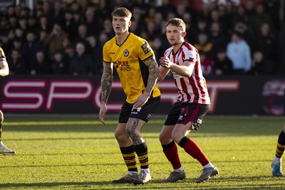 220225 - Newport County v Cheltenham Town - Sky Bet League 2 - Kai Whitmore of Newport County in action against Darragh Power of Cheltenham Town