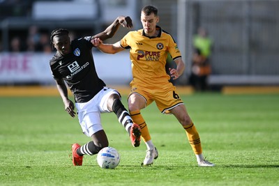 101026 - Newport County v Colchester United - Sky Bet League 2 - Ciaran Brennan of Newport County is challenged by Moses Sesay of Colchester