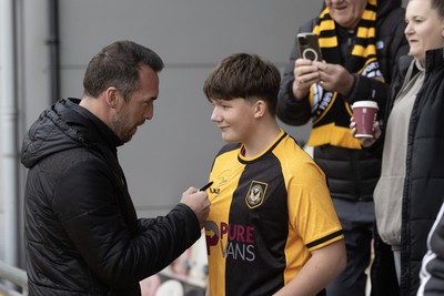 070326 - Newport County v Colchester United - Sky Bet League 2 - Newport County Manager Christian Fuchs signs a fans shirt before kick off