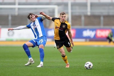 070326 - Newport County v Colchester United - Sky Bet League 2 - Sven Sprangler of Newport County wins a challenge with Finley Barbrook of Colchester United 