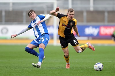 070326 - Newport County v Colchester United - Sky Bet League 2 - Sven Sprangler of Newport County wins a challenge with Finley Barbrook of Colchester United 
