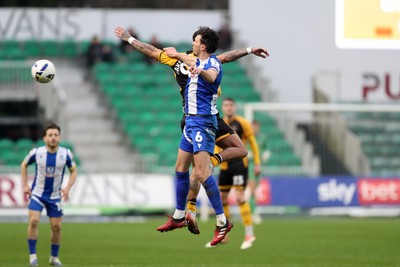 070326 - Newport County v Colchester United - Sky Bet League 2 - Tom Flanagan of Colchester United wins a header against Nathan Opoku of Newport County