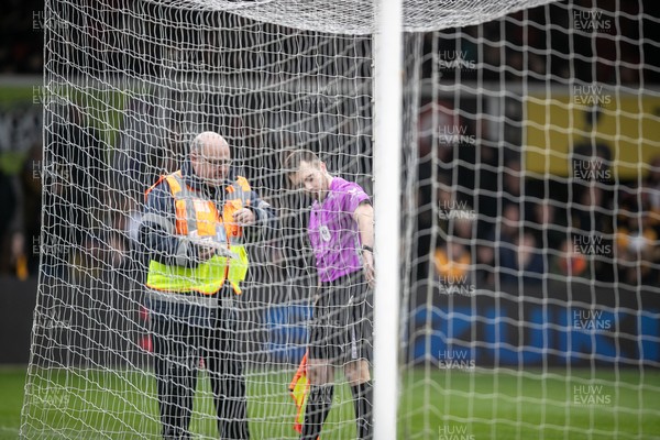 070326 - Newport County v Colchester United - Sky Bet League 2 - Officials inspect one of the nets which delayed kick off