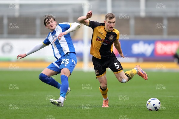 070326 - Newport County v Colchester United - Sky Bet League 2 - Sven Sprangler of Newport County wins a challenge with Finley Barbrook of Colchester United 