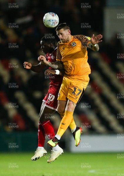221019 - Newport County v Crawley Town, Sky Bet League 2 - Scot Bennett of Newport County heads the ball forward as Bez Lubala of Crawley Town challenges