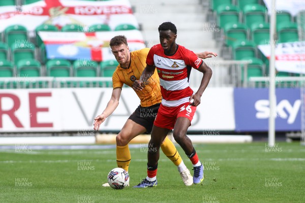 120823 - Newport County v Doncaster Rovers - Sky Bet League 2 - Ryan Delaney of Newport County holds up Mo Fai of Doncaster Rovers