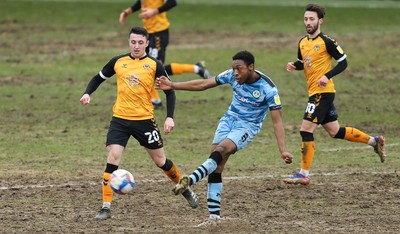 210221 Newport County v Forest Green Rovers, Sky Bet League 2 - Ebrima Adams of Forest Green Rovers plays the ball forward at Anthony Hartigan of Newport County  looks on
