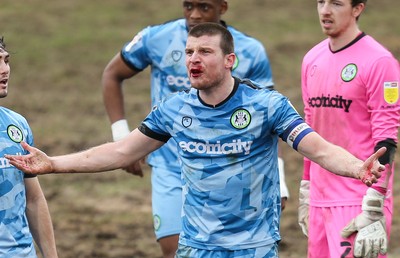 210221 Newport County v Forest Green Rovers, Sky Bet League 2 - Chris Stokes of Forest Green Rovers reacts after being hit in the face by Ryan Taylor of Newport County as competed for the ball