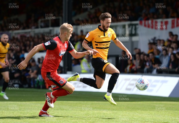 250818 - Newport County v Grimsby Town - SkyBet League 2 - Josh Sheehan of Newport County is tackled by Harry Davis of Grimsby Town