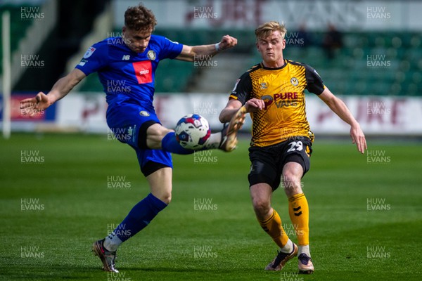 250423 - Newport County v Harrogate Town - Sky Bet League 2 - Toby Sims of Harrogate Town attempts to clear under pressure from Will Evans of Newport County